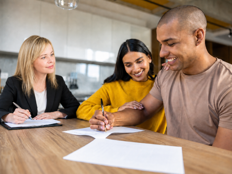 Clients signing a real estate agreement with their lawyer